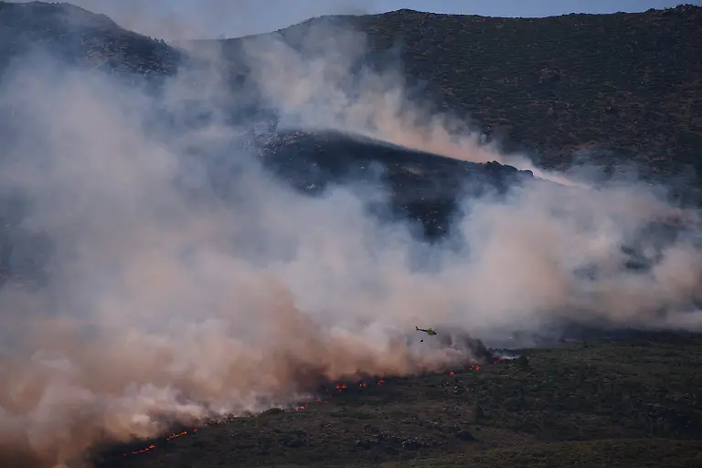 Ein-Loeschhubschrauber-wirft-Wasser-auf-die-Flammen-waehrend-sich-ein-Waldbrand-in-der-Naehe-von-Burgohondo-in-der-Provinz-Avila-ausbreitet