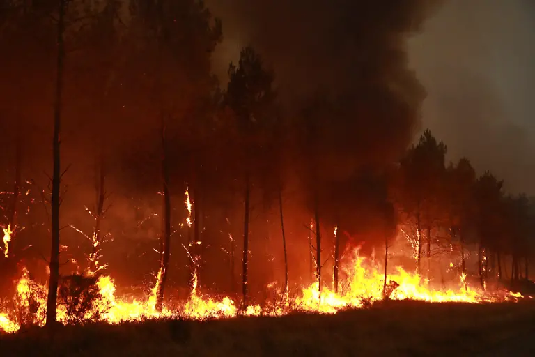 SAINT-JEAN-D-ILLAC-FRANCE-JULY-26-Firefighting-operations-continue-as-a-wildfire-burns-near-Saint-Jean-d-Illac-in-southwestern-France-on-July-26-2026-Fire-engines-heavy-machinery-and-a-firefighting-helicopter-are-deployed-to-contain-the-blaze-while-firefighters-battle-the-fire-on-the-ground-French-Interior-Minister-Laurent-Nunez-warns-that-the-situation-remains-highly-unfavorable