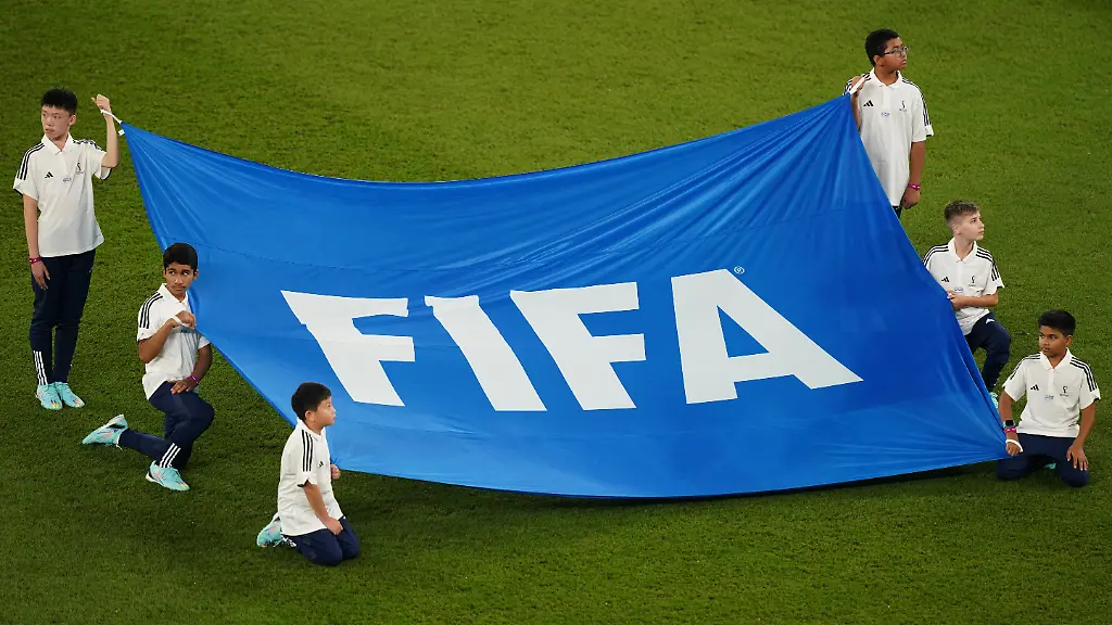 Fussball-WM-Frankreich-Daenemark-Vorrunde-Gruppe-D-Spieltag-2-Stadion-974-Kinder-halten-ein-Banner-mit-der-Aufschrift-FIFA-Der-Verband-entzieht-Indonesien-die-U20-WM