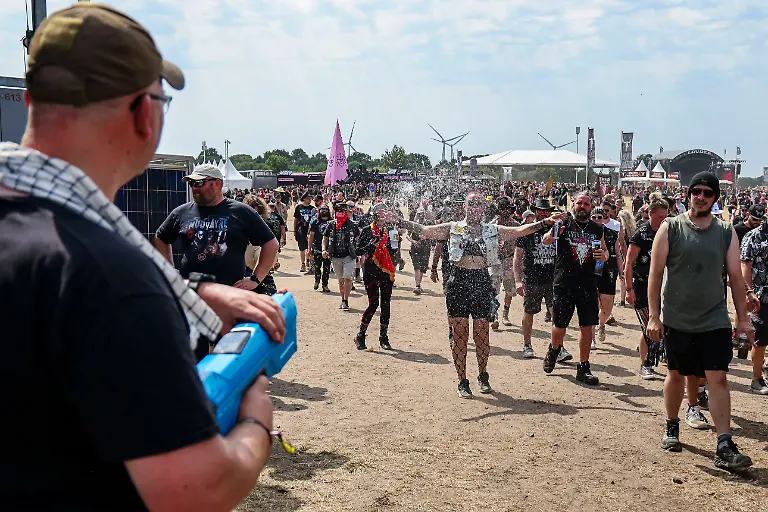 Festivalbesuchende-lassen-sich-beim-Wacken-Open-Air-W-O-A-von-einer-Wasserpistole-erfrischen-Das-W-O-A-gilt-als-groesstes-Heavy-Metal-Festival-der-Welt