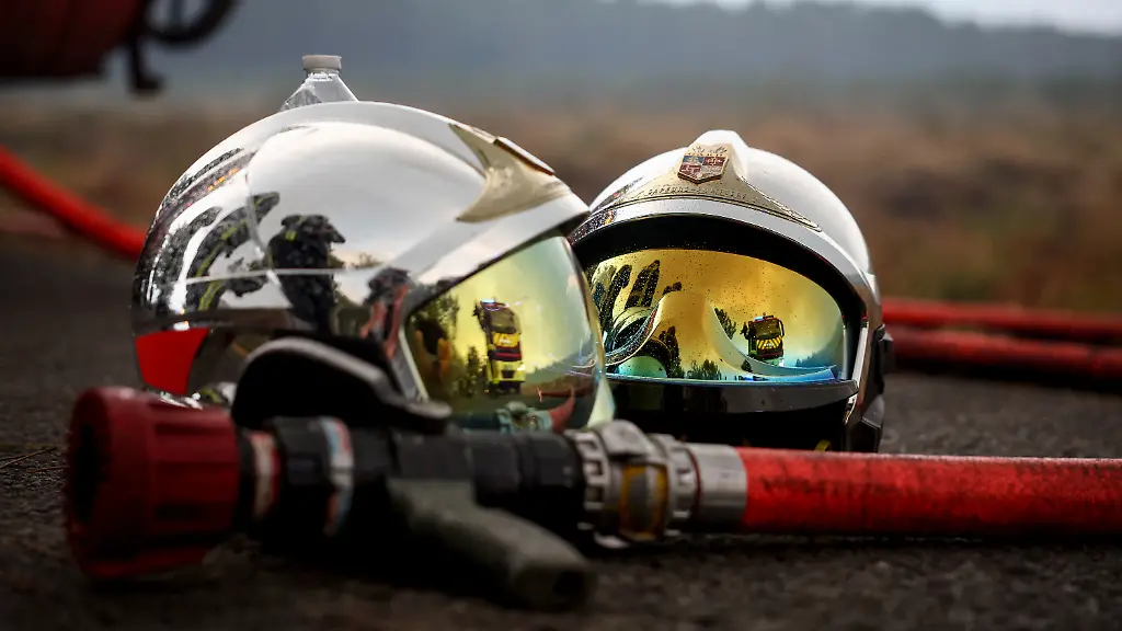 Two-firefighters-helmet-and-a-fire-hose-are-pictured-on-the-ground-as-a-forest-fire-rages-in-Saint-Jean-d-Illac-some-30km-from-Bordeaux-on-July-26-2026-as-a-wildfire-has-been-ravaging-the-forest-north-of-the-Arcachon-Basin-Gironde-The-220-000-people-evacuated-due-to-the-massive-wildfire-in-France-s-Gironde-region-will-not-be-able-to-return-home-until-the-fire-has-been-brought-under-control-the-local-prefect-said-also-ruling-out-any-normal-workday-on-Monday-in-the-affected-towns-ahead-of-a-possible-worsening-of-the-situation-on-Tuesday-due-to-an-expected-rise-in-temperatures