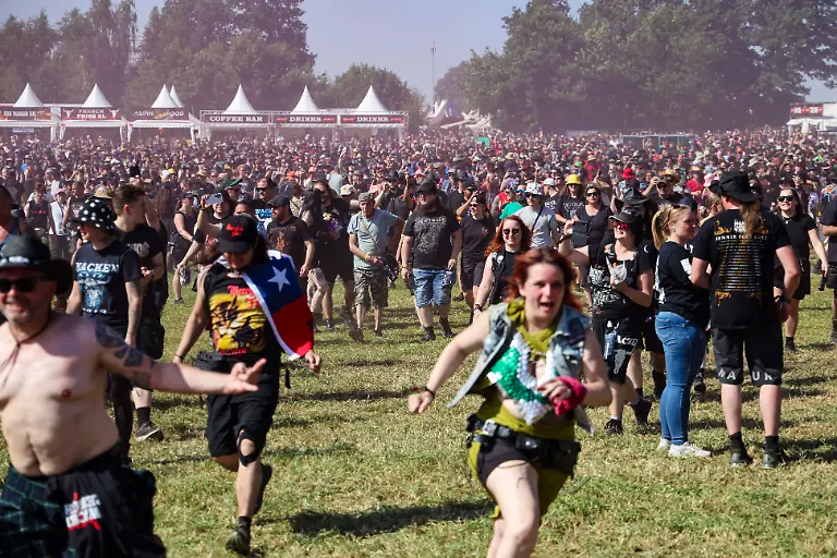 Festivalbesuchende-laufen-waehrend-der-Eroeffnung-auf-das-Infield-beim-Wacken-Open-Air-W-O-A-Das-W-O-A-gilt-als-groesstes-Heavy-Metal-Festival-der-Welt
