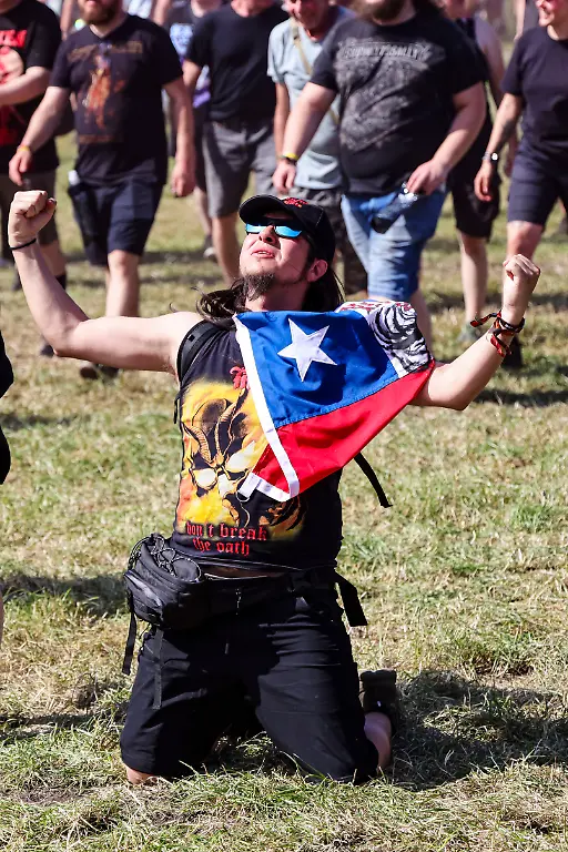 Ein-Mann-kniet-waehrend-der-Eroeffnung-auf-dem-Infield-beim-Wacken-Open-Air-W-O-A-Das-W-O-A-gilt-als-groesstes-Heavy-Metal-Festival-der-Welt
