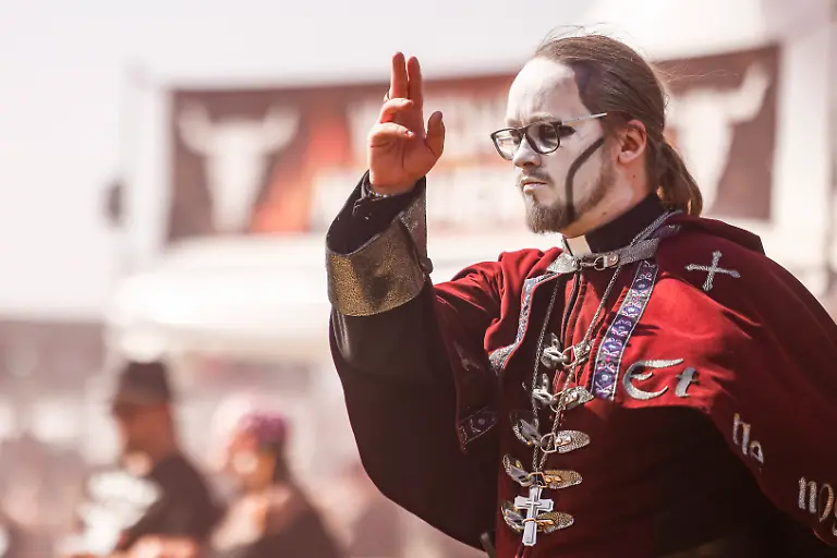 Ein-als-Priester-verkleideter-Mann-geht-ueber-das-Infield-waehrend-der-Eroeffnung-des-Wacken-Open-Air-W-O-A-Das-W-O-A-gilt-als-groesstes-Heavy-Metal-Festival-der-Welt