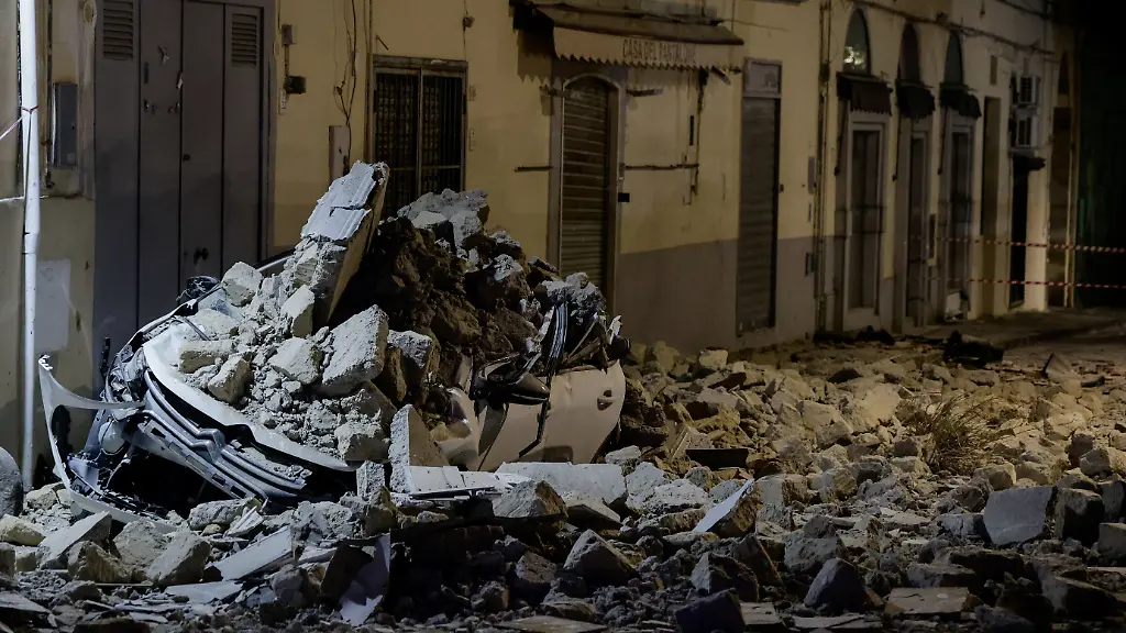 A-car-crushed-by-rubble-stand-on-a-debris-covered-Via-Pergolesi-after-a-magnitude-4-7-earthquake-struck-the-Campi-Flegrei-area-in-Pozzuoli-Italy-July-31-2026