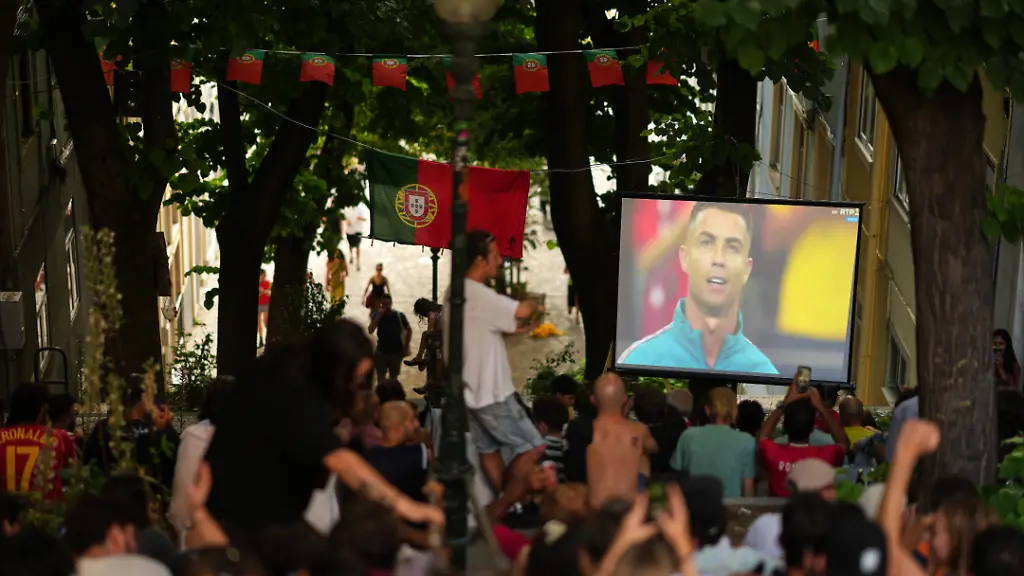 Fans-sitting-on-the-steps-of-a-pedestrian-street-in-Lisbon-Portugal-watch-a-screen-showing-Portugal-s-Cristiano-Ronaldo-before-the-kickoff-of-the-World-Cup-round-of-16-soccer-match-between-Portugal-and-Spain-Monday-July-6-2026