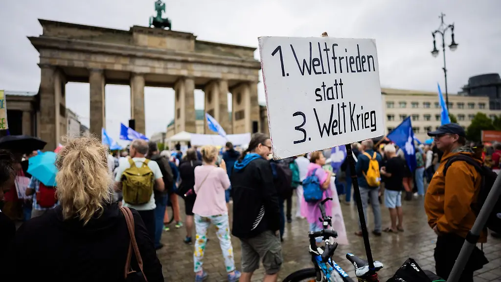 Teilnehmer-einer-Demonstration-des-Buendnisses-Wir-sind-viele-forderten-auf-einem-Plakat-1-Weltfrieden-statt-3-Weltkrieg