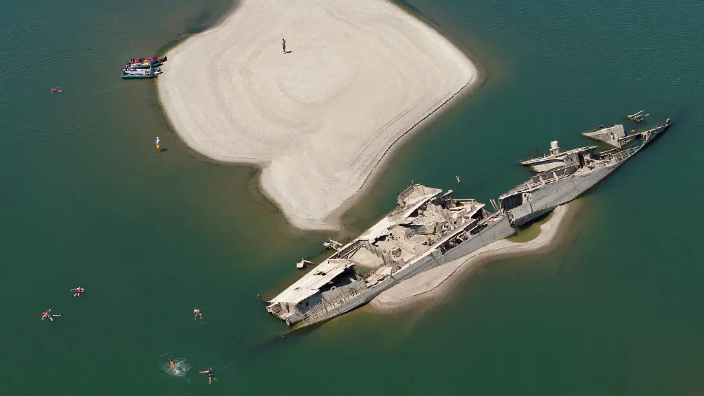 A-drone-view-shows-people-swimming-near-a-sunken-German-warship-from-World-War-II-exposed-due-to-low-Danube-River-levels-caused-by-drought-and-extreme-heat-in-Prahovo-Serbia-July-30-2026