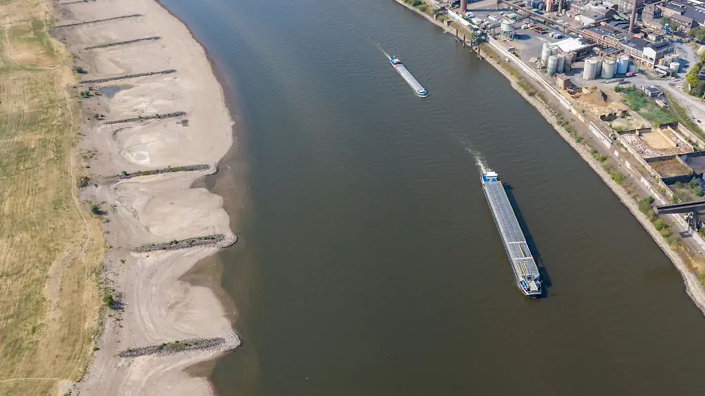 ARCHIV-30-07-2026-Nordrhein-Westfalen-Duisburg-Am-Rhein-in-Duisburg-fahren-Schiffe-in-der-Fahrrinne-am-Ufer-sind-breite-Sandbaenke-sichtbar-die-bei-normalem-Wasserstand-unter-Wasser-sind