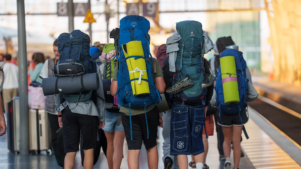 Ein-Reisegruppe-mit-Rucksaecken-ist-im-Hauptbahnhof-unterwegs-Die-Deutsche-Bahn-AG-legt-ihre-Halbjahresbilanz-vor-Demnach-schreibt-das-Verkehrsunternehmen-im-Kernbereich-erstmals-seit-sieben-Jahren-wieder-schwarze-Zahlen-und-verzeichnet-einen-Gewinn-im-dreistelligen-Millionenbereich