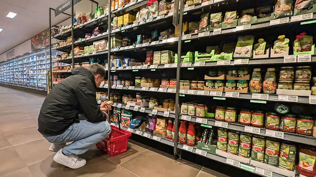 Ein-Kunde-betrachtet-das-Angebot-an-Bio-Fertigprodukten-in-einem-Supermarkt