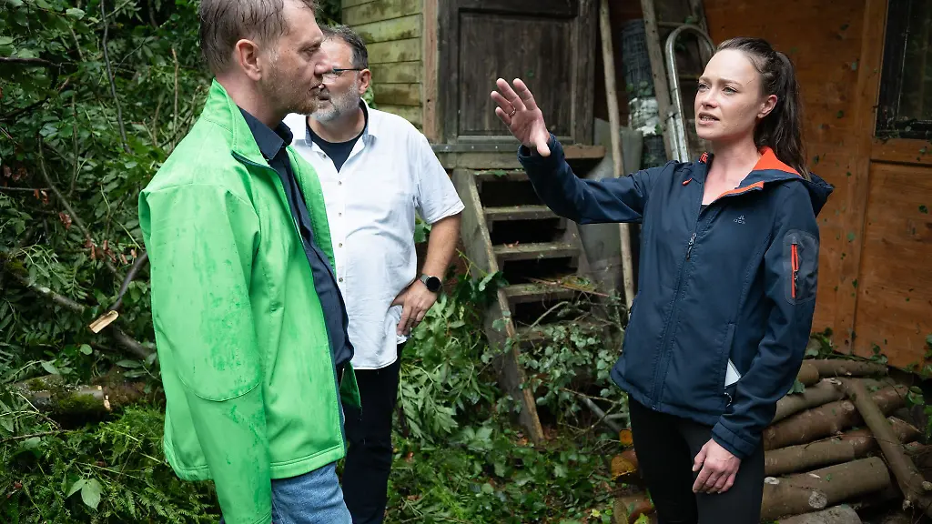 Das-Unwetter-hat-einen-Imbiss-am-Amselsee-verwuestet-Sachsens-Ministerpraesident-Michael-Kretschmer-spricht-mit-der-TV-und-Eventkoechin-Verena-Leister