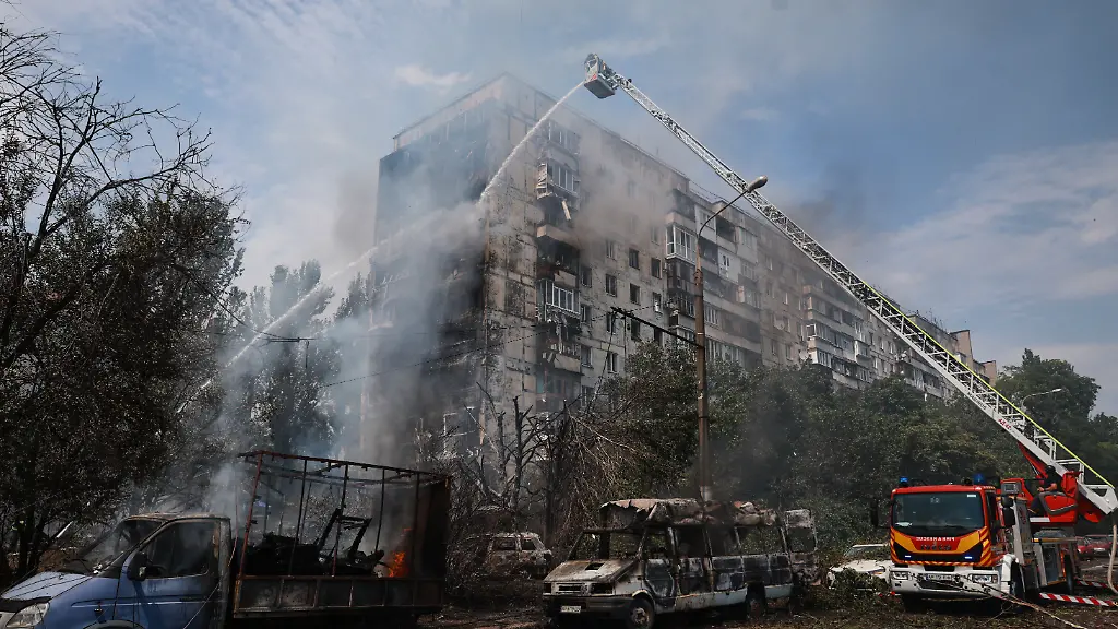 Rettungskraefte-versuchen-einen-Brand-in-einem-Wohnhaus-zu-loeschen-das-nach-einem-russischen-Luftangriff-mit-einer-luftgelenkten-Bombe-in-Flammen-steht