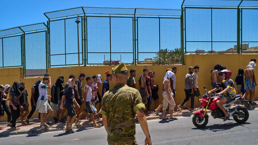 Migranten-die-nach-Spanien-eingereist-sind-werden-von-spanischen-Soldaten-in-Richtung-der-spanisch-marokkanischen-Grenze-begleitet-um-von-der-spanischen-Enklave-Ceuta-nach-Marokko-zurueckgefuehrt-zu-werden