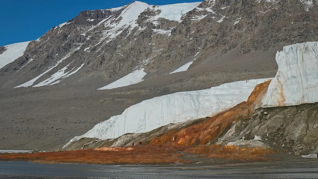 HANDOUT-Researchers-of-this-study-collecting-samples-at-Blood-Falls-a-feature-of-the-Taylor-Glacier-Antarctica-where-iron-rich-subglacial-brine-emerges-creating-the-striking-red-outflow-that-flows-into-proglacial-west-lobe-of-Lake-Bonney-Credit-Bryan-Minnea-ACHTUNG-Frei-nur-zur-redaktionellen-Verwendung-im-Zusammenhang-mit-der-Berichterstattung-ueber-die-Studie-bei-Nennung-des-Credits