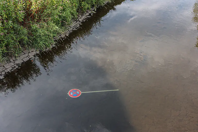 Sommer-im-Siegerland-Der-Fluss-Sieg-wie-hier-bei-Niederschelden-fuehrt-fuehrt-zur-Zeit-wenig-Wasser-Niedrigwasser-Die-Bezirksregierung-Arnsberg-untersagt-daher-die-Wasserentnahme-im-Regierungsbezirk-u-a-aus-der-Sieg-aufgrund-anhaltender-Trockenheit-Ein-Verkehrszeichen-liegt-im-Wasser-Sommer-im-Siegerland-am-03-08-2026-in-Siegen-Deutschland