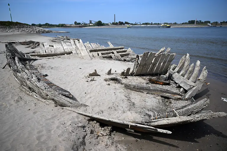 Durch-das-Niedrigwasser-ist-auf-dem-Rhein-das-Wrack-des-einstigen-Holz-Frachtschiffes-De-Hoop-aus-dem-spaeten-19-Jahrhundert-aufgetaucht-1895-hatte-sich-beim-Umladen-von-Dynamit-eine-Explosion-ereignet-bei-der-16-Menschen-starben-und-das-Schiff-zerstoert-wurde-Das-Rekord-Niedrigwasser-des-Rheins-hat-in-Nordrhein-Westfalen-seinen-tiefsten-Stand-wahrscheinlich-bisher-nicht-erreicht-Laut-Prognose-des-Wasserstrassen-und-Schifffahrtsamtes-Rhein-werden-am-06-und-07-August-2026-noch-drastischere-Tiefstaende-fuer-Koeln-Duesseldorf-Duisburg-Ruhrort-und-Emmerich-erwartet