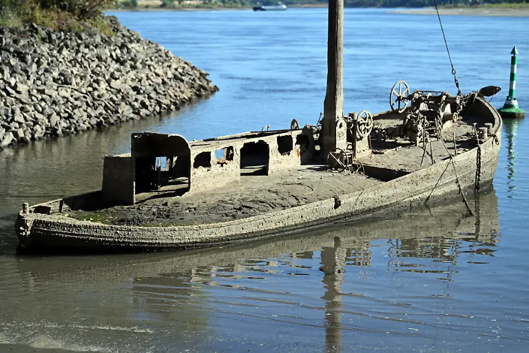 Ein-Schiffswrack-ist-am-Rhein-zu-sehen-Wegen-des-niedrigen-Wasserstands-ist-der-Aalschokker-an-der-Muendung-zum-Silberseee-wieder-zu-sehen-Durch-langanhaltende-Trockenheit-ist-der-Pegel-im-Rhein-sehr-niedrig-Auf-dem-vielbefahrenen-Rhein-wird-ein-historischer-Tiefstand-befuerchtet