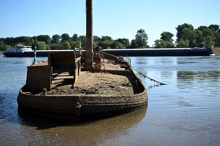Ein-Schiffswrack-ist-am-Rhein-zu-sehen-Wegen-des-niedrigen-Wasserstands-ist-der-Aalschokker-an-der-Muendung-zum-Silberseee-wieder-zu-sehen-Durch-langanhaltende-Trockenheit-ist-der-Pegel-im-Rhein-sehr-niedrig-Auf-dem-vielbefahrenen-Rhein-wird-ein-historischer-Tiefstand-befuerchtet