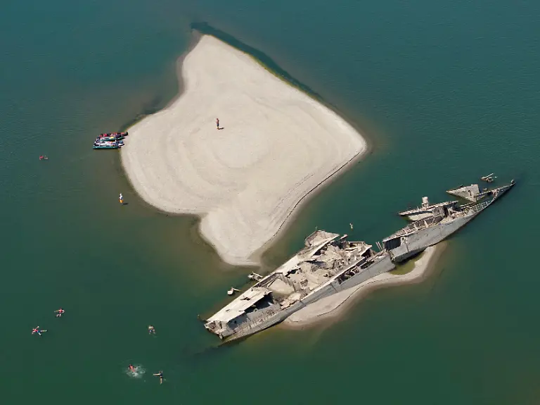 A-drone-view-shows-people-swimming-near-a-sunken-German-warship-from-World-War-II-exposed-due-to-low-Danube-River-levels-caused-by-drought-and-extreme-heat-in-Prahovo-Serbia-July-30-2026