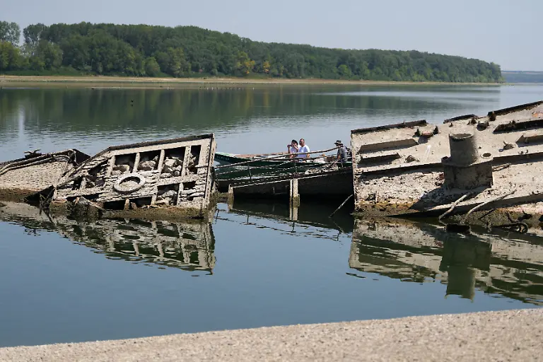 04-08-2026-Serbien-Prahovo-Menschen-betrachten-das-Wrack-eines-deutschen-Kriegsschiffs-aus-dem-Zweiten-Weltkrieg-das-aufgrund-der-Duerre-vor-dem-Djerdap-II-Staudamm-an-der-Donau-zwischen-Rumaenien-und-Serbien-freigelegt-wurde