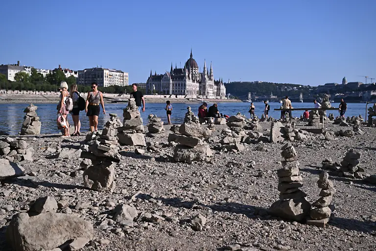 People-walk-on-the-dried-out-waterbed-of-the-river-Danube-under-the-Margaret-Bridge-in-downtown-Budapest-Hungary-on-July-30-2026-The-water-level-of-the-Danube-in-the-capital-Budapest-was-measured-at-23-centimeters-which-is-close-to-the-lowest-values-ever-recorded-According-to-data-from-the-National-Directorate-of-Water-Management-the-river-has-dropped-significantly-along-the-entire-Hungarian-section-of-the-Danube
