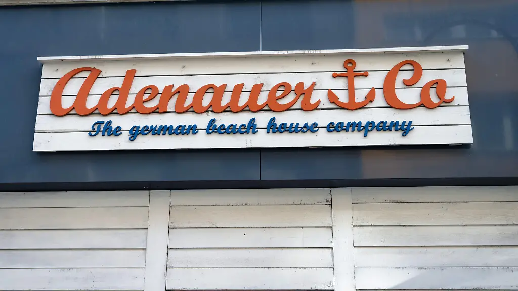 Nahaufnahme-des-hoelzernen-Adenauer-Co-Schildes-im-Beach-House-Stil-an-der-Filiale-in-der-Koelner-Einkaufsstrasse-Breite-Strasse
