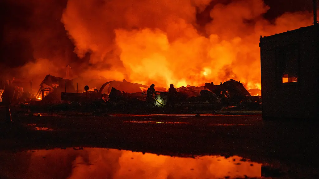 Feuerwehrleute-loeschten-einen-Brand-nachdem-russische-Raketen-ein-Lagerhaus-getroffen-hatten
