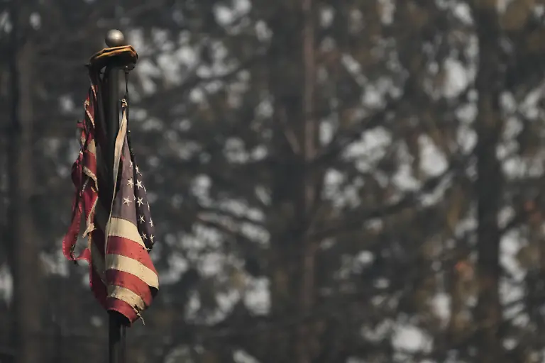 A-burned-American-flag-hangs-on-a-flagpole-after-a-wildfire-hit-the-northern-part-of-Spokane-Wash-Tuesday-Aug-4-2026