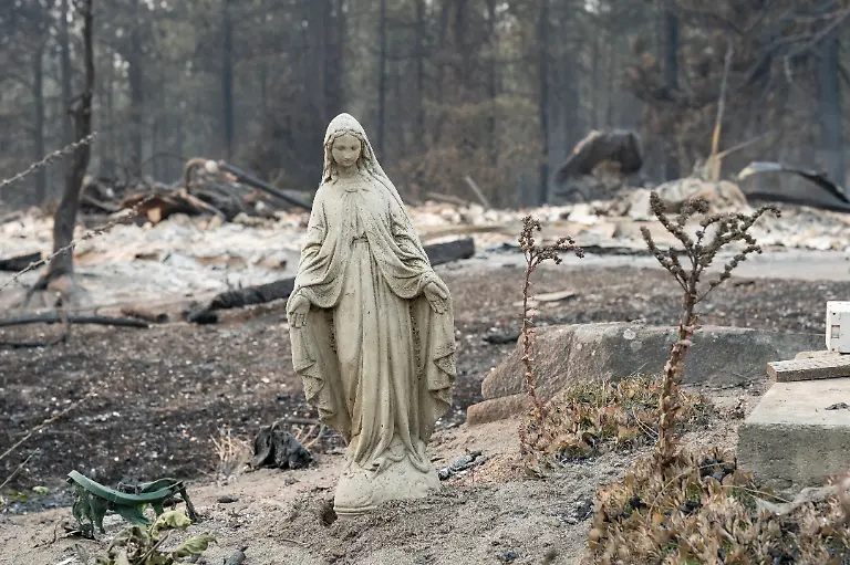 A-Virgin-Mary-statue-remains-untouched-in-front-of-a-burned-out-residential-home-in-the-Balboa-neighborhood-of-Spokane-Washington-on-August-2-2026-Fast-moving-fires-left-a-trail-of-destruction-in-the-northwestern-US-city-of-Spokane-on-Sunday-with-officials-reporting-hundreds-of-structures-reduced-to-cinders-Thousands-of-people-were-ordered-to-evacuate-their-homes-Saturday-and-overnight-into-Sunday-as-three-separate-fires-broke-out-in-and-around-the-city-in-the-east-of-Washington-state
