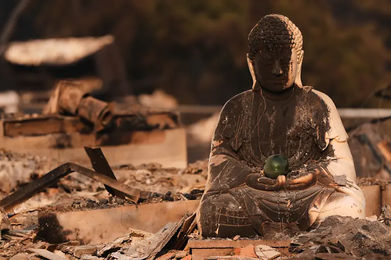 A-Buddha-statue-is-seen-with-fire-damage-amongst-the-rubble-of-a-house-burned-after-a-wildfire-hit-the-northern-part-of-Spokane-Wash-Monday-Aug-3-2026