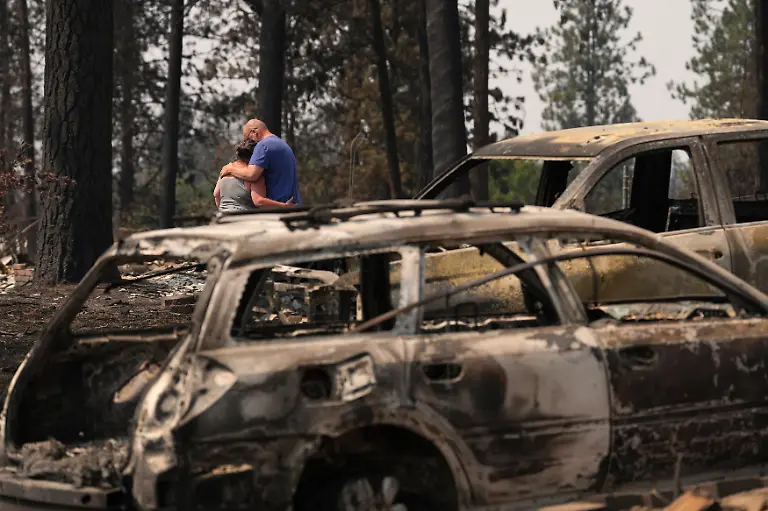 Michelle-Angstrom-left-hugs-husband-Wayne-Angstrom-as-they-survey-the-remains-of-their-home-after-a-wildfire-hit-the-northwest-part-of-Spokane-Wash-Tuesday-Aug-4-2026