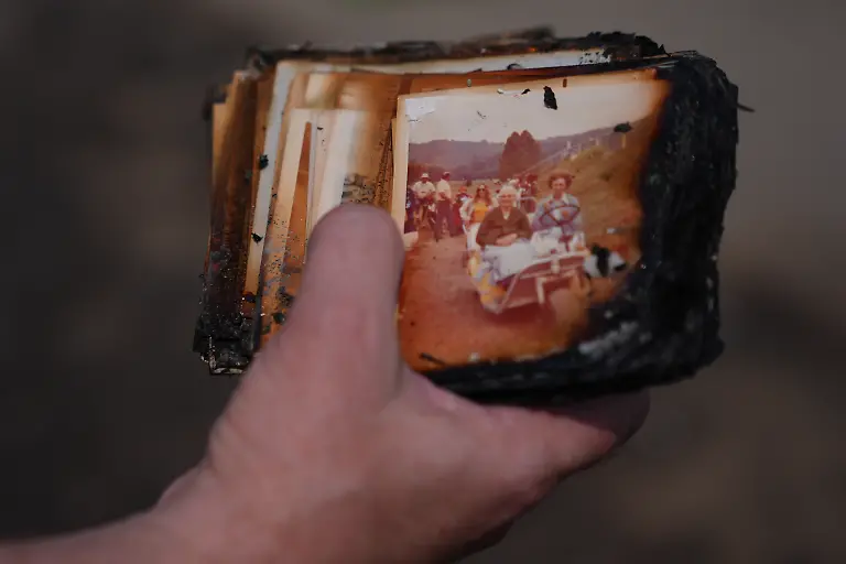 Mike-Wirth-holds-family-photos-retrieved-from-his-father-in-law-s-home-after-a-wildfire-hit-the-northwest-part-of-Spokane-Wash-Tuesday-Aug-4-2026