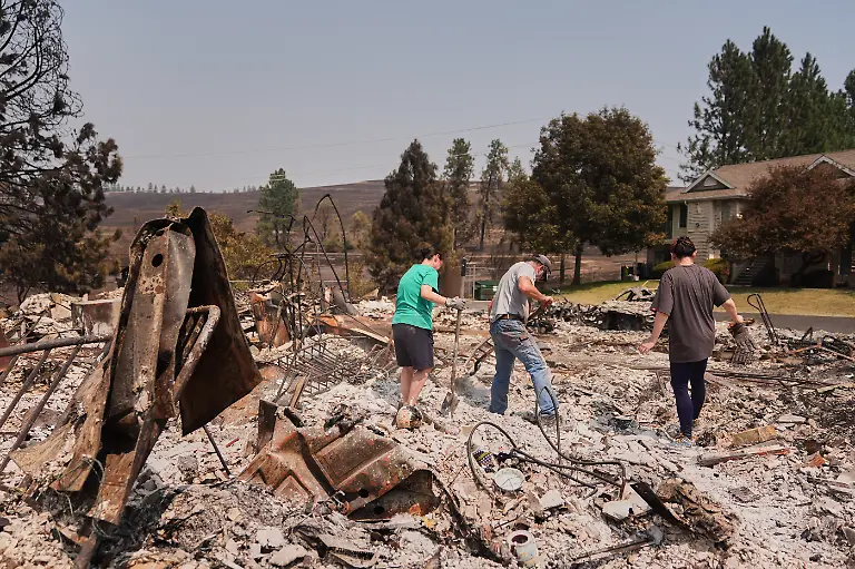 Resident-Donna-Light-right-works-with-friends-and-family-including-sister-Kristy-Reed-left-to-look-for-possessions-after-a-wildfire-hit-the-northwest-part-of-Spokane-Wash-Tuesday-Aug-4-2026