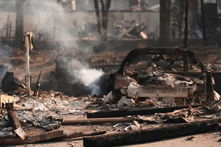 A-car-smolders-in-rubble-after-a-wildfire-hit-the-northern-part-of-Spokane-Wash-Monday-Aug-3-2026