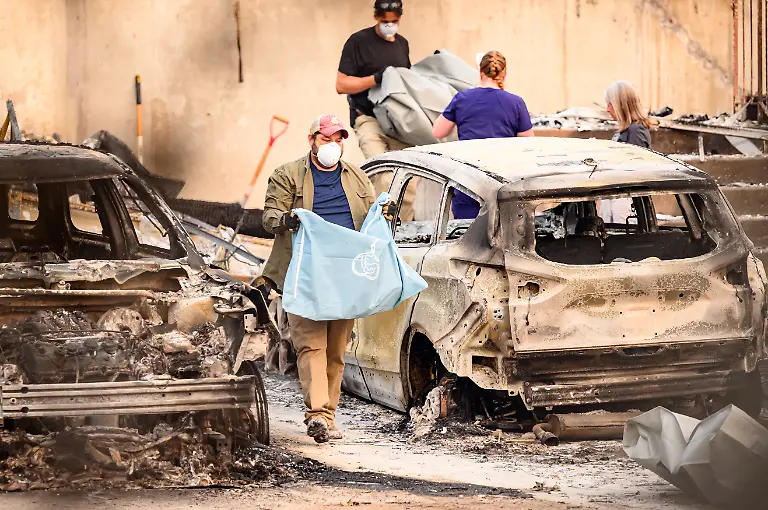 Residents-carry-the-remains-of-deceased-dogs-at-a-burned-home-during-the-Old-Trails-fire-in-Spokane-Washington-on-August-4-2026-US-authorities-arrested-a-man-on-August-3-2026-on-suspicion-of-arson-in-connection-with-the-biggest-of-three-fires-burning-around-the-northwestern-city-of-Spokane-as-firefighters-raced-to-contain-flames-that-have-displaced-tens-of-thousands-Wildfires-supercharged-by-drought-and-intense-heat-have-torn-through-the-city-in-Washington-state-burning-thousands-of-acres-and-reducing-hundreds-of-buildings-to-cinders-while-anxious-families-await-news-on-when-they-can-return
