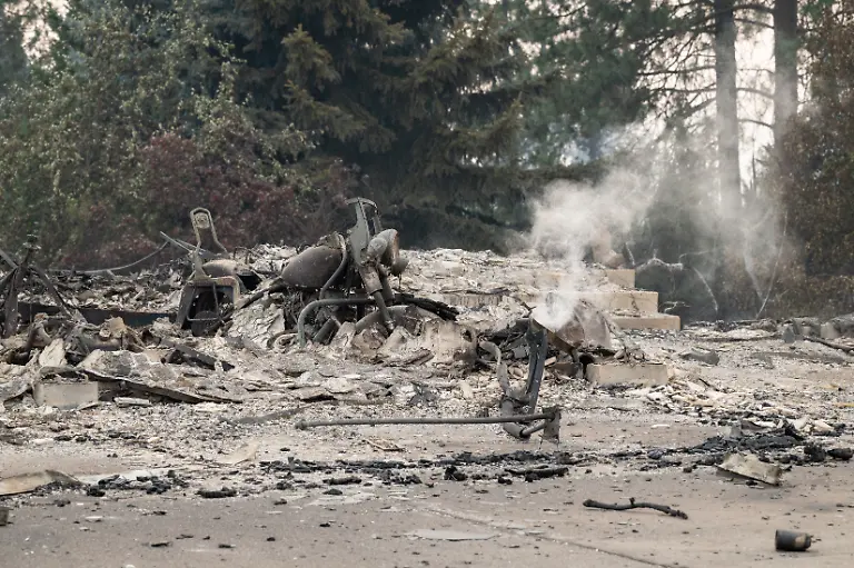 A-burned-motorcycle-sits-in-the-ashes-of-burned-out-residential-home-in-the-Balboa-neighborhood-of-Spokane-Washington-on-August-2-2026-Fast-moving-fires-left-a-trail-of-destruction-in-the-northwestern-US-city-of-Spokane-on-Sunday-with-officials-reporting-hundreds-of-structures-reduced-to-cinders-Thousands-of-people-were-ordered-to-evacuate-their-homes-Saturday-and-overnight-into-Sunday-as-three-separate-fires-broke-out-in-and-around-the-city-in-the-east-of-Washington-state