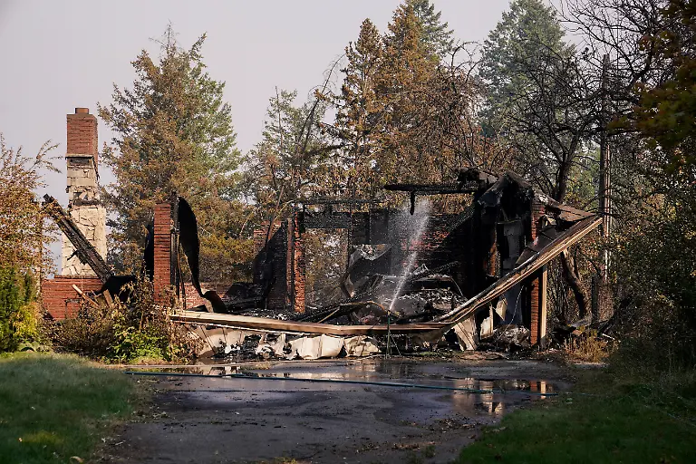 Water-is-sprayed-on-the-remains-of-a-house-burned-by-the-Old-Trails-Fire-in-Spokane-Washington-U-S-August-3-2026