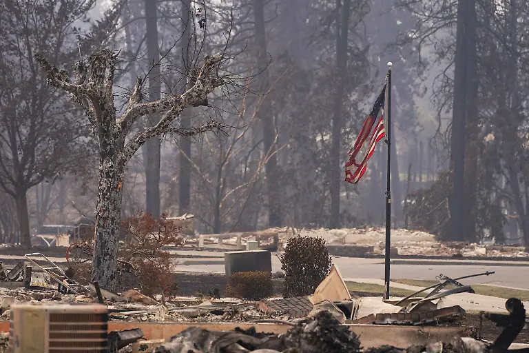 A-torn-American-flag-flutters-among-incinerated-neigbourhood-in-the-Old-Trails-Fire-in-Spokane-Washington-U-S-August-3-2026