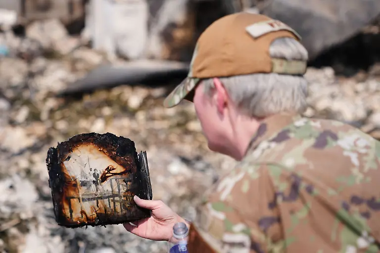 Sgt-Wirth-of-the-Washington-Air-National-Guard-holds-up-a-family-photo-retrieved-from-her-father-s-home-after-a-wildfire-hit-the-northwest-part-of-Spokane-Wash-Tuesday-Aug-4-2026