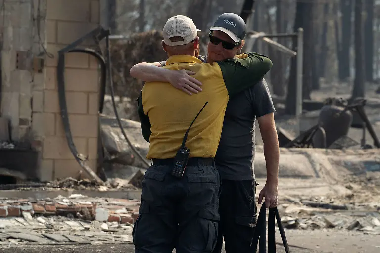 A-wildfire-victim-whose-home-burned-during-the-Old-Trails-fire-hugs-a-firefighter-medic-after-surveying-his-lost-home-in-Spokane-Washington-U-S-August-4-2026