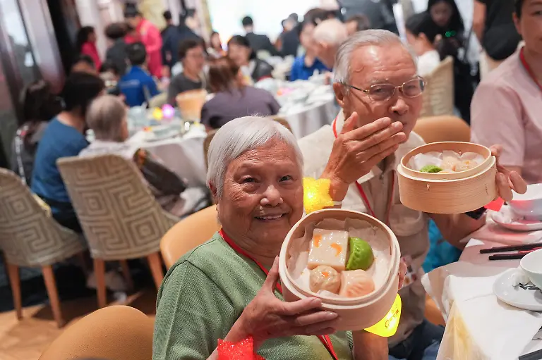 Ms-Lau-and-Mr-Lee-both-in-their-80s-pose-for-a-photo-as-Maxims-Catering-Group-and-Council-of-Social-Service-hold-a-dimsum-session-with-soft-meals-for-100-elderly-people-and-their-family-at-a-Tsuen-Wan-mall-12MAY26
