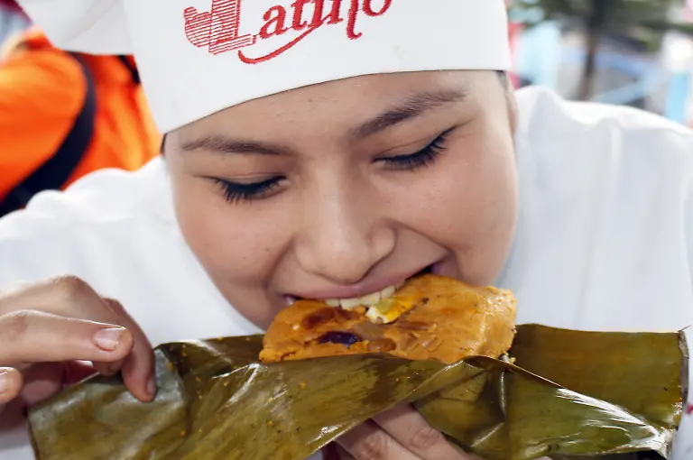 170612-LIMA-June-12-2017-A-woman-tastes-a-tamale-during-an-activity-of-a-gastronomic-fair-in-Lima-Peru-on-June-11-2017-During-the-activity-tamales-were-prepared-with-an-ancient-recipe-in-27-hours-by-300-students-from-a-chef-institute