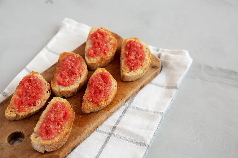 Homemade-Pan-Con-Tomate-Tomato-Toast-on-a-Rustic-Wooden-Board-side-view