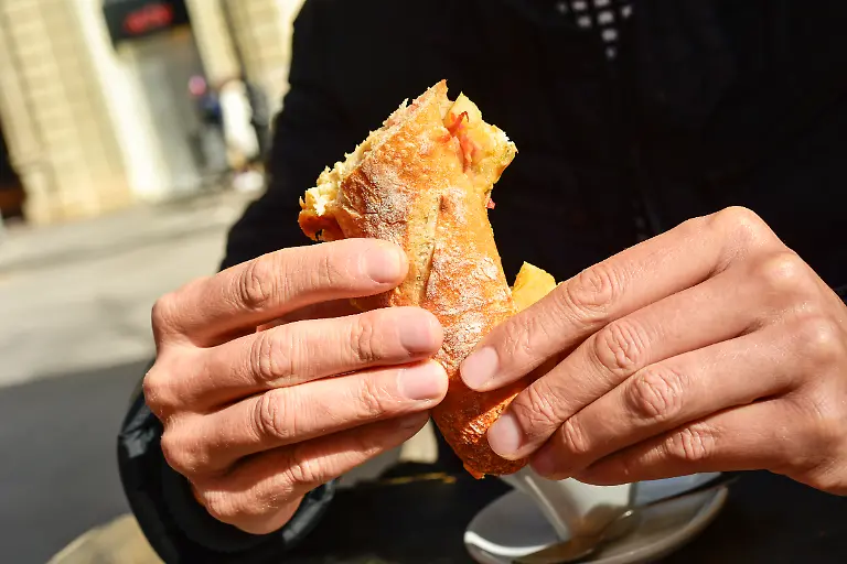 young-man-sitting-in-a-table-in-the-terrace-of-a-cafe-eating-a-spanish-omelette-sandwich-xkwx-spanish-cuisine-spanish-food-spanish-omelette-tortilla-de-patatas-omelette-omelet-sandwich-tortilla-patatas-tortilla-espanola-espanola-man-young-table-terrace-cafe-cafeteria-restaurant-coffee-shop-shop-breakfast-cup-of-coffee-cup-bocadillo-de-tortilla-bocadillo-potatoes-snack-meal-eating-continental-breakfast-continental-ceramic-porcelain-dish-plate-typical-gastronomy-cuisine-culinary-outdoors-lifestyle-place-spain-horizontal