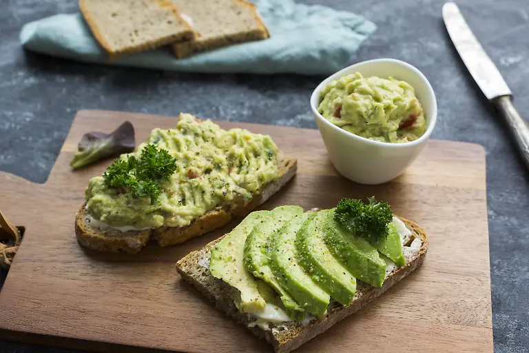 Slices-of-bread-with-sliced-avocado-and-avocado-cream-on-wooden-board-PUBLICATIONxINxGERxSUIxAUTxHUNxONLY-JUNF01412
