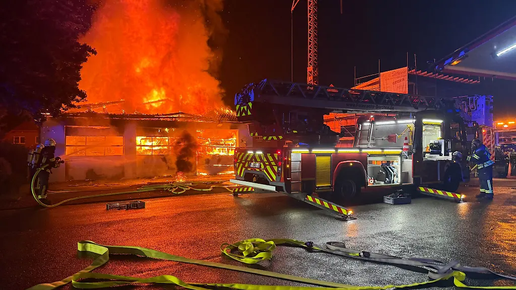Einsatzkraefte-der-Feuerwehr-versuchen-das-in-Flammen-stehende-Geraetehaus-zu-loeschen