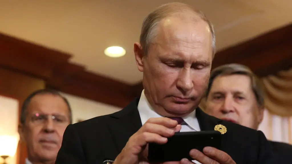 DA-NANG-VIETNAM-NOVEMBER-10-RUSSIA-OUT-Russian-President-Vladimir-Putin-C-holds-an-iPhone-as-his-spokesman-Dmitry-Peskov-R-looks-on-prioir-to-a-bilateral-meeting-with-Philippines-President-Rodrigo-Duterte-not-pictured-at-the-APEC-Leaders-Summit-on-November-10-2017-in-Da-Nang-Vietnam-Russian-President-Vladimir-Putin-has-arrived-to-Vietnam-to-attends-the-APEC-Leaders-Summit