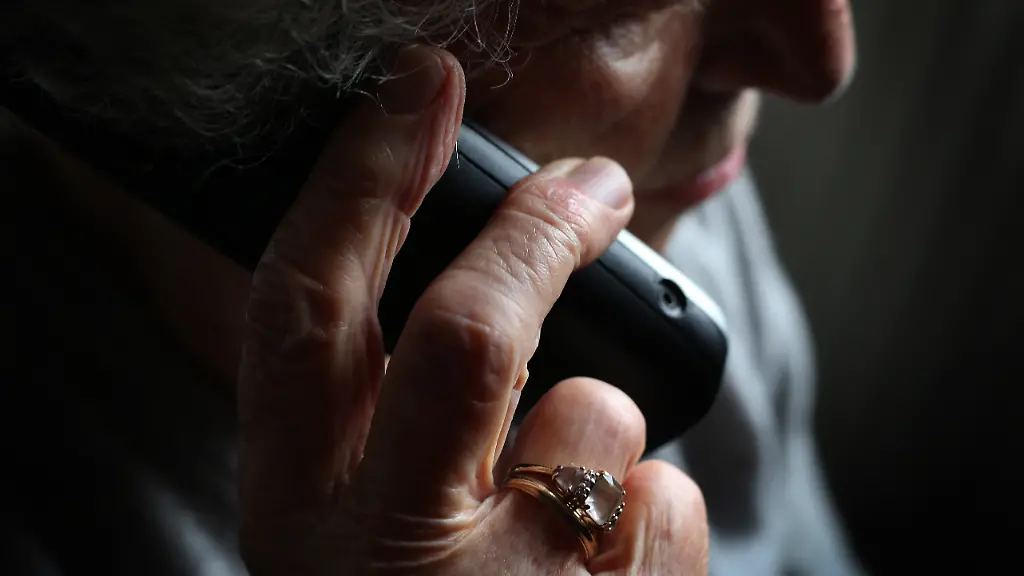 ARCHIV-11-10-2019-Bayern-Wuerzburg-Eine-aeltere-Frau-telefoniert-mit-einem-schnurlosen-Festnetztelefon-Die-meisten-betruegerischen-Anrufe-wie-die-sogenannten-Enkeltricks-und-Schockanrufe-stammen-aus-dem-Ausland