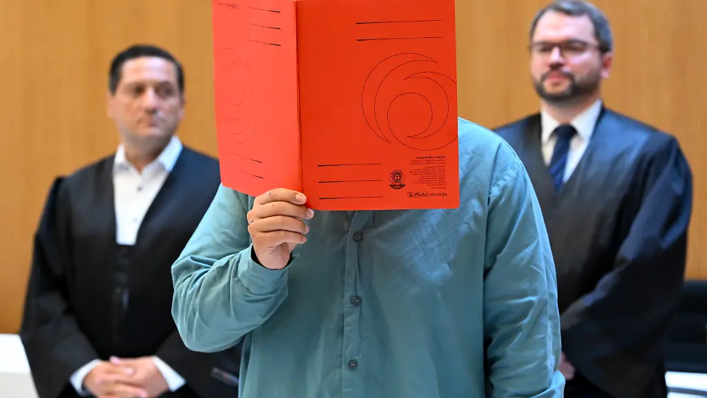 Der-Angeklagte-Farhad-N-M-steht-zu-Prozessbeginn-mit-seinen-Anwaelten-Oemer-Sahinci-l-und-Johann-Bund-r-im-Prozesssaal